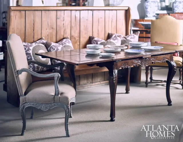 Dining room with a wooden banquette, upholstered chairs, and a dark wood table set with plates.