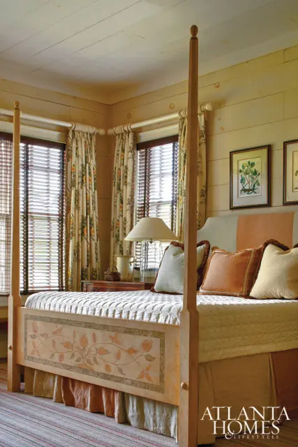Bedroom with a four-poster bed featuring hand-painted floral motifs, paneled walls, and floral curtains.