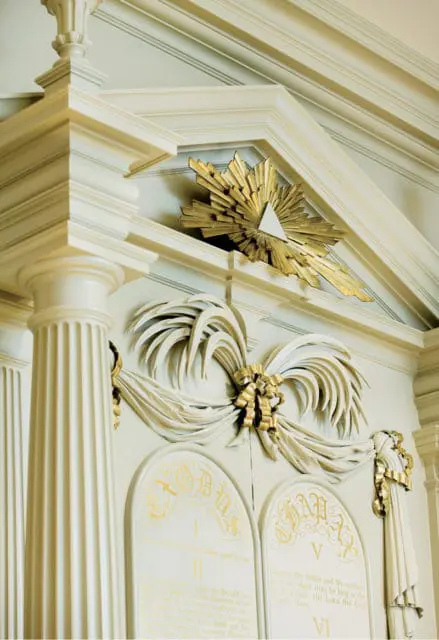 Cream-colored architectural detail with gold sunburst and Ten Commandments text.