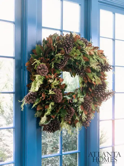 Magnolia leaf and pine cone wreath on a blue door