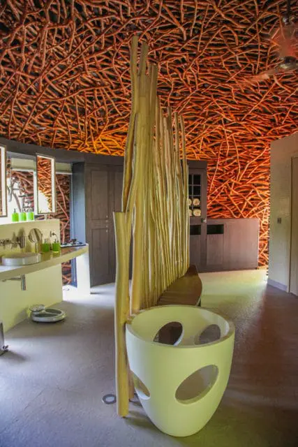 Wooden ceiling with bamboo accents, a vanity, and a sculptural chair.
