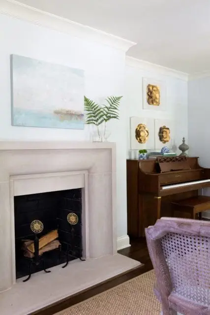 Living room with a light gray stone fireplace, abstract landscape painting, and a brown upright piano.