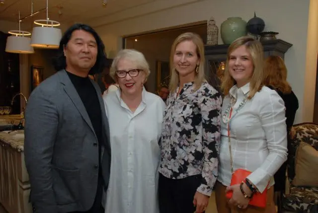 Asian man, woman in glasses, and two women smiling in a room.