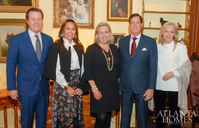 Five people pose for a photo in a room with artwork on the walls. The Atlanta Homes & Lifestyles logo is visible in the bottom right corner.