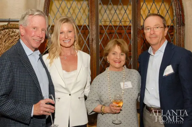 Four people posing for a photo, two men and two women, holding wine glasses. The Atlanta Homes & Lifestyles logo is visible in the lower right corner.