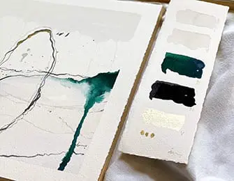 Watercolor painting with abstract lines and green washes next to a swatch card with paint samples in white, green, black, and gold