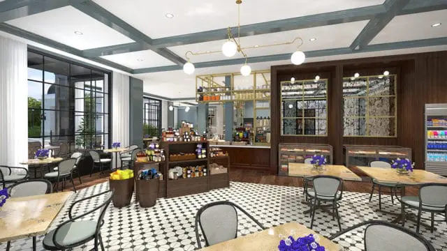 Bistro interior with black and white tile floor, dark wood shelving stocked with jars and food items, and seating areas with marble-topped tables and dark metal chairs.