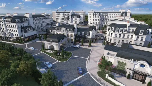 Rendering of a European-inspired village with white buildings, mansard roofs, and manicured landscaping. Cars are parked on cobblestone streets.