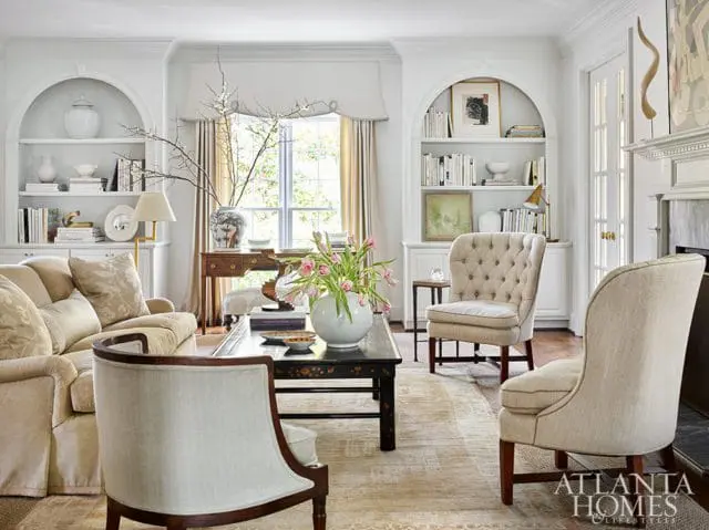 white living room with arched bookshelves