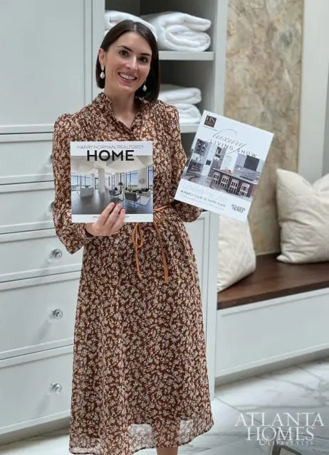 Woman in a floral dress holds two magazines, one titled 'Harry Norman, Realtors Home' and the other 'Luxury Living Show'