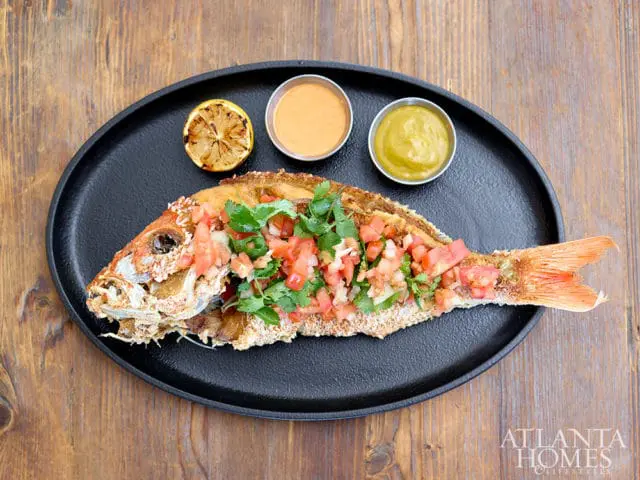 Whole fried fish topped with pico de gallo and cilantro, served with lemon and sauces.