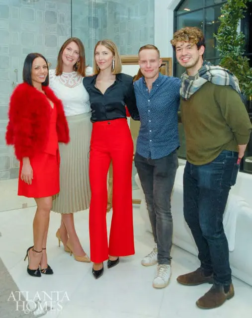 Five people posing in a modern bathroom. The Atlanta Homes & Lifestyles logo is visible.