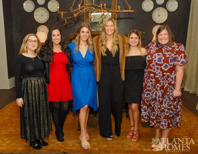Six women posing for a photo indoors.