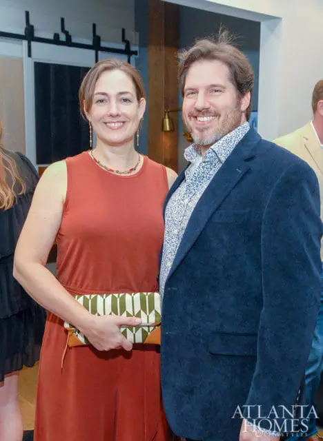 Woman in rust jumpsuit and man in navy jacket and patterned shirt