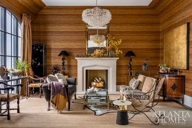 Living room with wood-paneled walls, fireplace, and eclectic furniture.