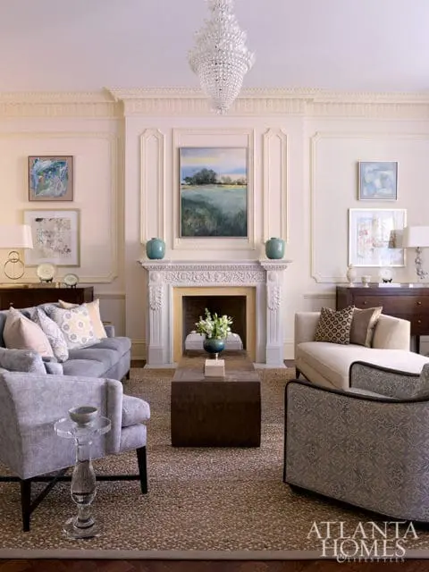 Living room with fireplace, crystal chandelier, and patterned furniture.