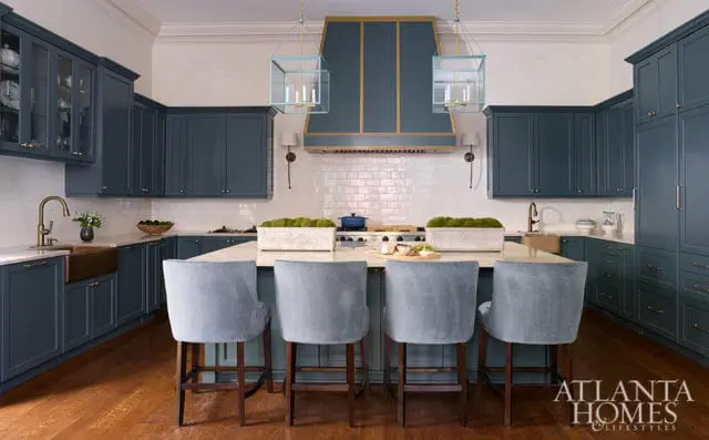 Navy blue kitchen cabinets, white subway tile backsplash, and light blue bar stools.