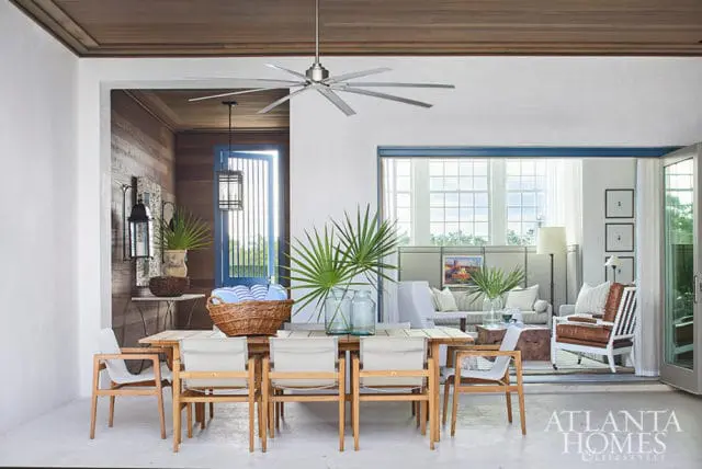 Dining area with wooden table and chairs, leading to a living room with sofas and chairs.