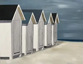 Row of white beach huts with dark roofs against a cloudy sky and calm sea