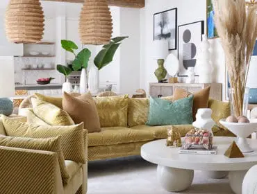 Living room with yellow corduroy sofa, striped armchairs, and white coffee table.