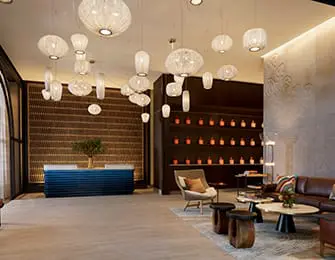 Lobby with blue reception desk, leather sofa, and numerous pendant lights