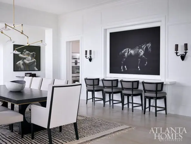 Dining room with black table, white chairs, and large framed art of a horse.