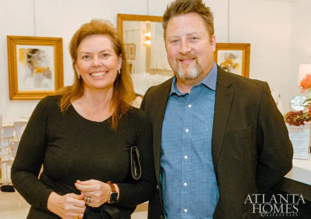 Woman in black top and man in blue checkered shirt and dark jacket smiling