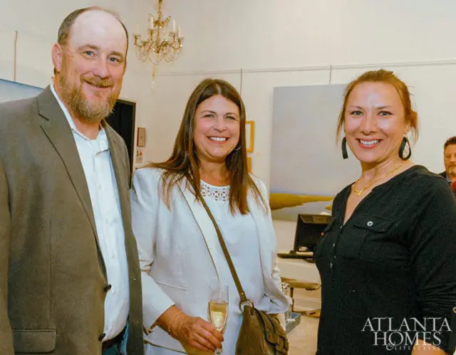 Three people smiling, with Atlanta Homes & Lifestyles logo in lower right corner.