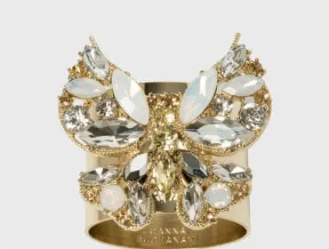 Gold cuff bracelet with butterfly design encrusted with clear and opalescent crystals.
