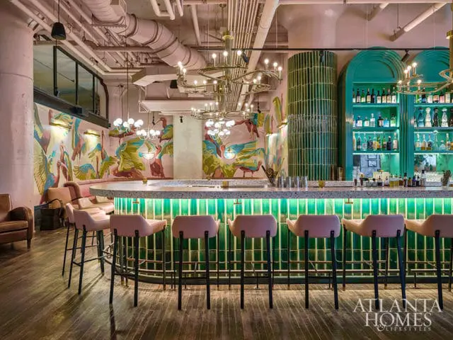Bar with pink stools, terrazzo counter, and a mural of birds.