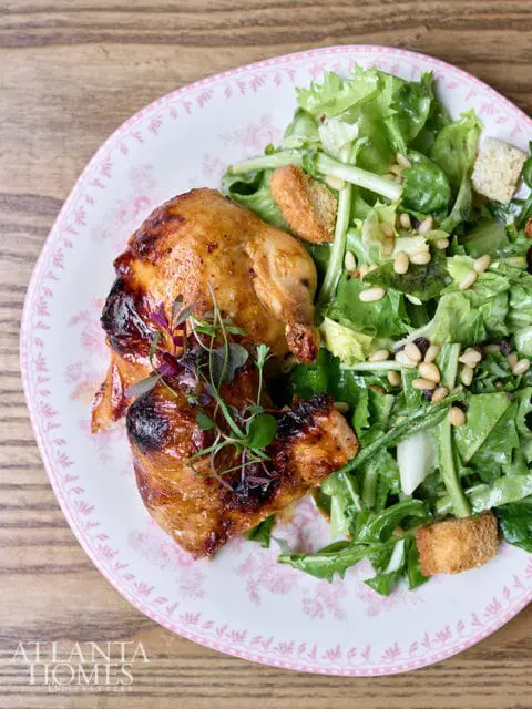Roasted chicken with salad on a pink floral plate