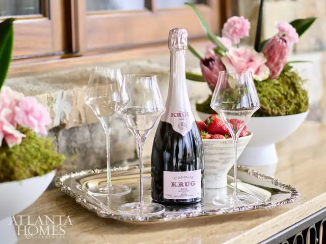 Krug champagne bottle with two glasses and strawberries on a silver tray