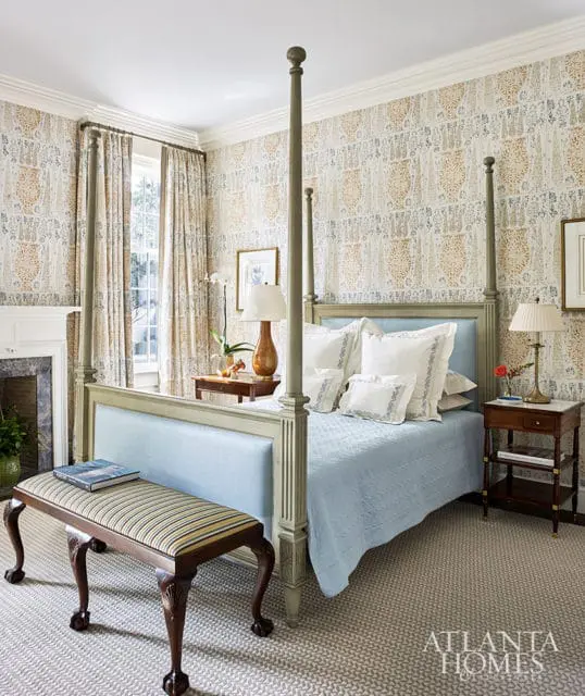 Bedroom with a four-poster bed, patterned wallpaper, and upholstered bench.
