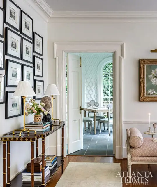 Hallway with gallery wall, console table, and doorway to dining room.