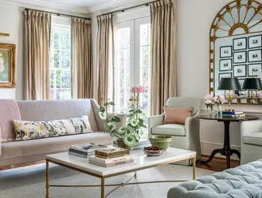 Living room with a beige sofa, light green armchairs, and a marble coffee table.