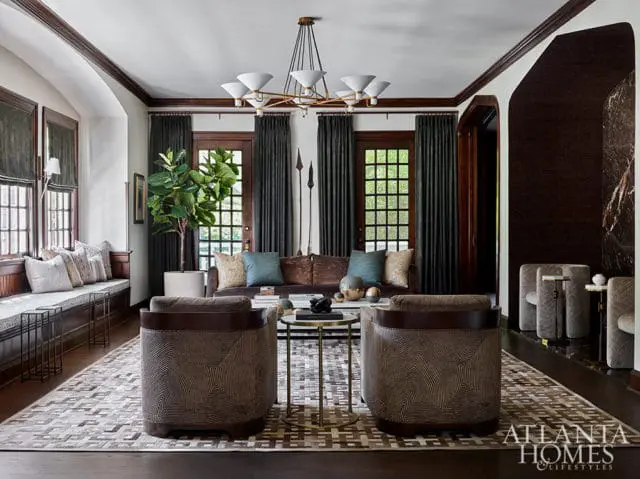Living room with dark wood trim, patterned chairs, and a brown sofa. Atlanta Homes & Lifestyles