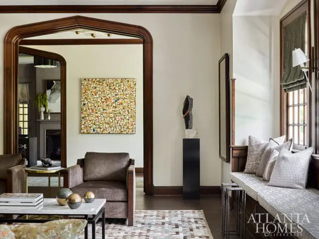 Living room with patterned chairs, abstract art, and a built-in window seat.