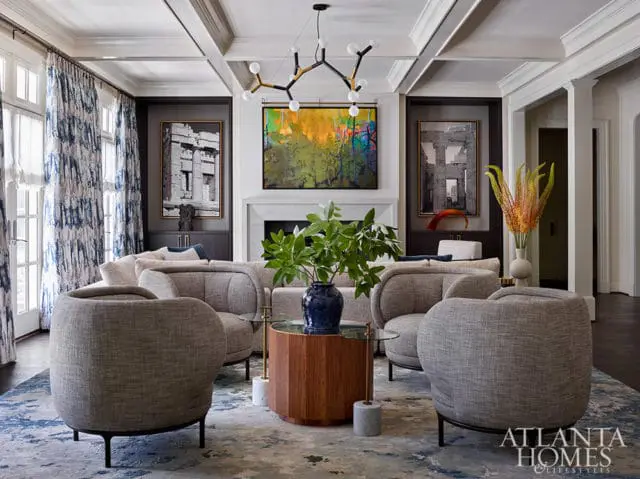 Living room with gray upholstered chairs, abstract art, and coffered ceiling.