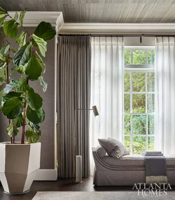 Gray chaise lounge by window with sheer curtains, large potted plant, and Atlanta Homes &