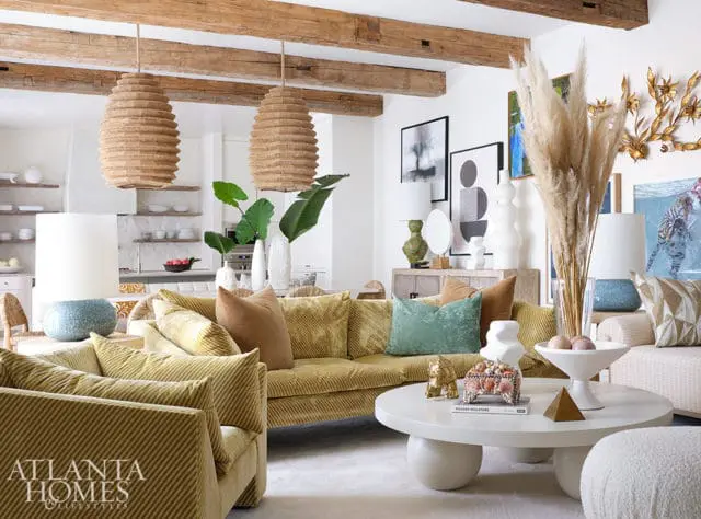 Living room with yellow corduroy sofa, pendant lights, and pampas grass.