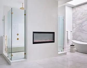 Modern white bathroom with glass shower enclosures, fireplace, and marble accent wall