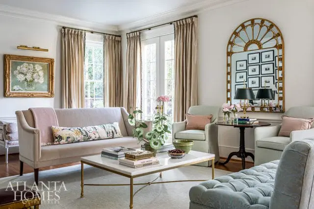Living room with light gray sofa, marble coffee table, and ornate gold mirror.