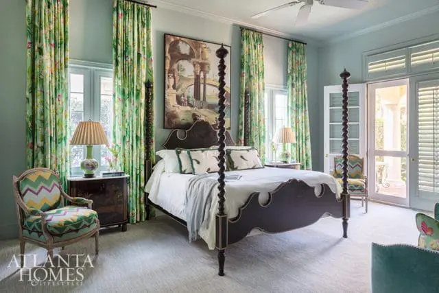 Bedroom with a four-poster bed, floral curtains, and patterned armchairs.