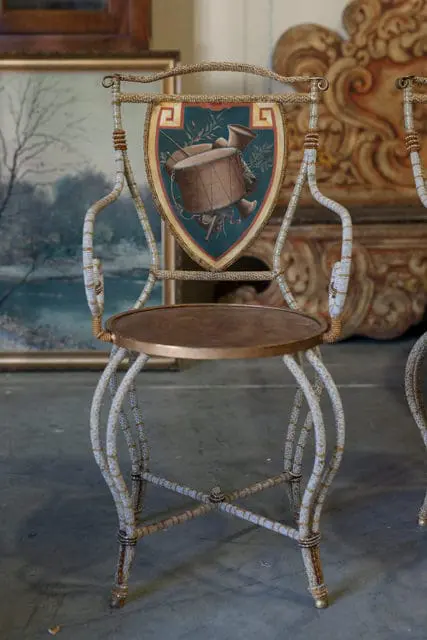 Chair back with painted shield depicting drum and horns, beaded frame