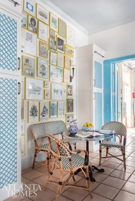 Dining area with gallery wall, blue lattice cabinets, and rattan chairs