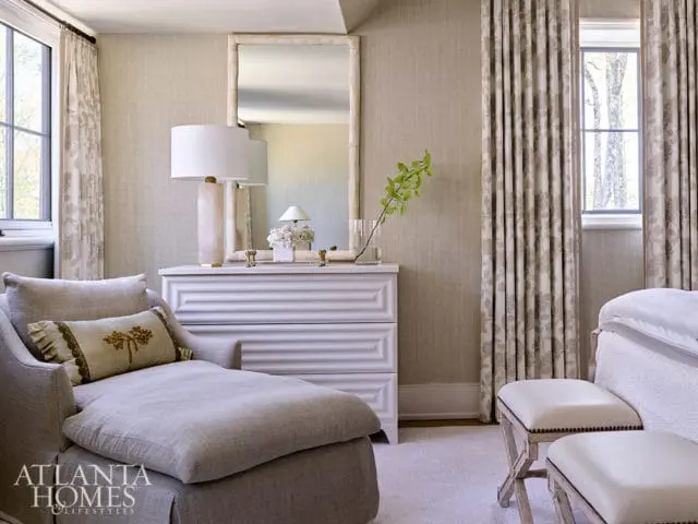 Neutral bedroom with chaise lounge, white dresser, and floral curtains.
