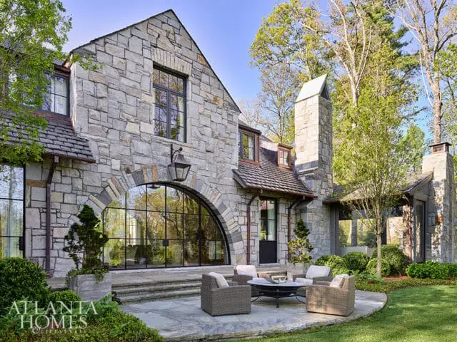 Stone house with arched window and patio seating area