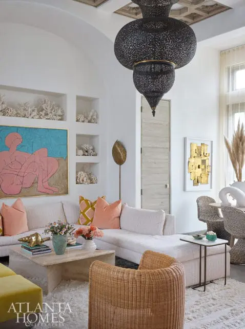 Living room with sectional sofa, rattan chairs, and ornate black lantern chandelier.