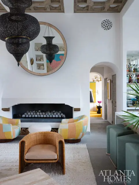 Living room with patterned chairs, wicker armchair, fireplace, and Atlanta Homes & Lifestyles logo.