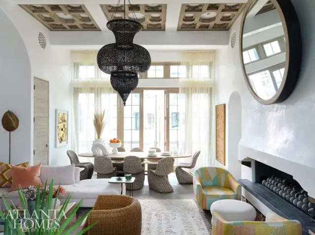 Living and dining room with white walls, ornate ceiling, black lantern chandelier, and rattan